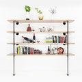 Industrial pipe wall shelf with 4 light wood shelves, styled with books, wine bottles, plant vases, and decorative items