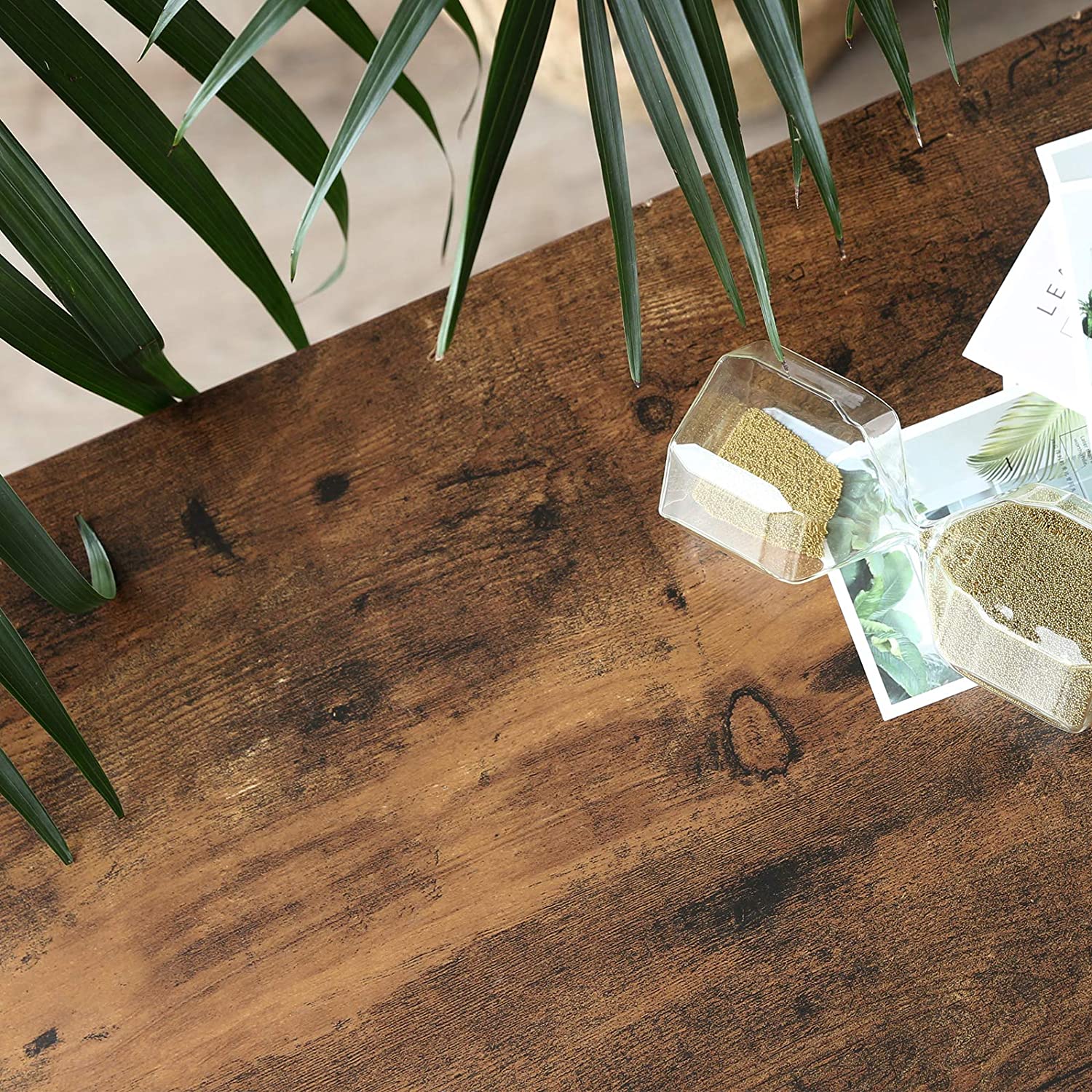 Close-up of rustic brown wood grain surface on industrial shoe bench top with palm frond and small glass container