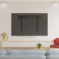 Fixed TV wall bracket lifestyle in white room large TV on wall white TV unit yellow watering can plant and blue sofa