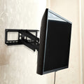Full-motion TV wall bracket with TV swiveled sideways in room with floral wallpaper showing extended arm
