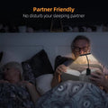 Man reading at night with clip-on LED book light while woman sleeps beside him, text reads Partner Friendly