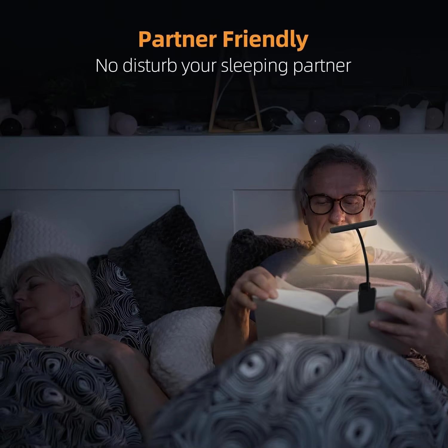 Man reading at night with clip-on LED book light while woman sleeps beside him, text reads Partner Friendly