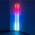 LED corner floor lamp lit with red, pink and blue gradient light projected onto dark room corner walls