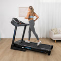 Woman running on Lifespan Apex 2 treadmill in home gym with wooden floor, white curtains and couch