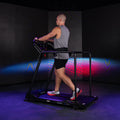 Runner in motion on Reformer 2 side view with colorful studio projection display