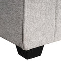 Close-up of light grey sofa lower corner showing textured woven fabric and black block leg