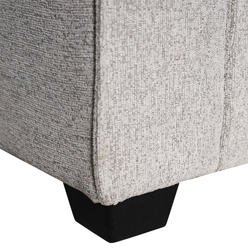 Close-up of light grey sofa lower corner showing textured woven fabric and black block leg
