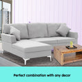 Light grey L-shape corner sofa in lifestyle room with lavender striped wall and wood coffee table