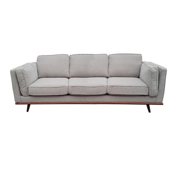 Light grey fabric 3-seater sofa front view on white background with wooden base rail and tapered legs