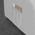 Close-up of light grey fabric recliner side pocket with 