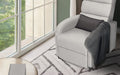 Light grey fabric recliner upright beside large window with dark grey cushion and throw, patterned rug, round coffee table