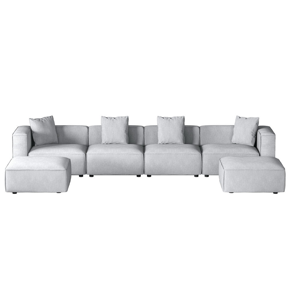 Light grey modular 4-seater sofa with ottomans on both sides, front view on white background