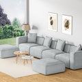 Light grey modular 4-seater sofa with left and right ottomans in bright living room with garden view