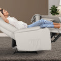 Woman reclining fully in light grey PU recliner with footrest extended, cup holder on armrest, side pocket visible, grey rug