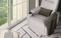 Light grey PU recliner with dark cushion and throw blanket, angled view beside large window, patterned rug, timber floor