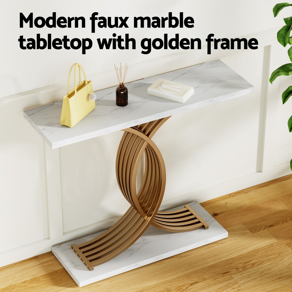 Marble console table with double curved gold arc base in entryway, styled with handbag, diffuser and books on top