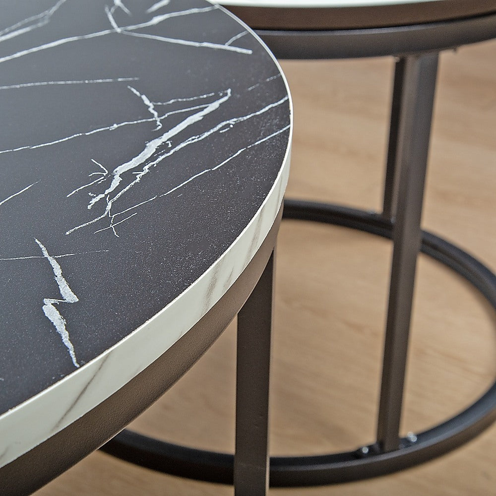 Close-up of smaller round nesting table showing black marble-effect top with white veining, white rim and bronze ring base