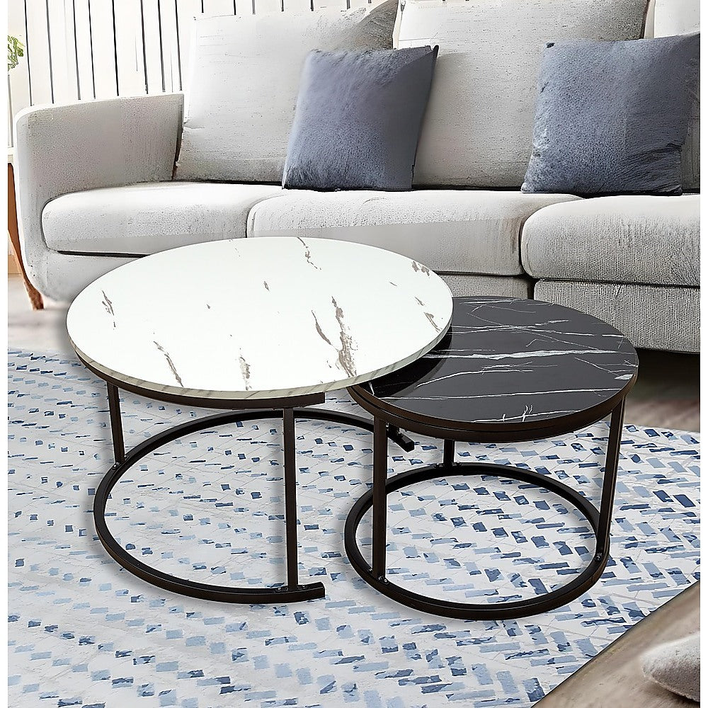 Two round nesting coffee tables with white marble and black marble tops on bronze metal ring bases on white background