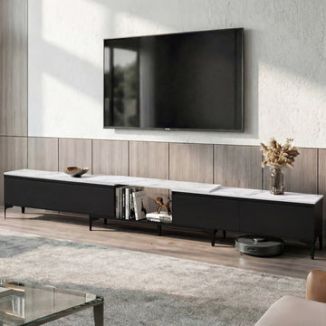 Black and white marble-top TV unit lifestyle with wood-panel wall vase and robot vacuum visible