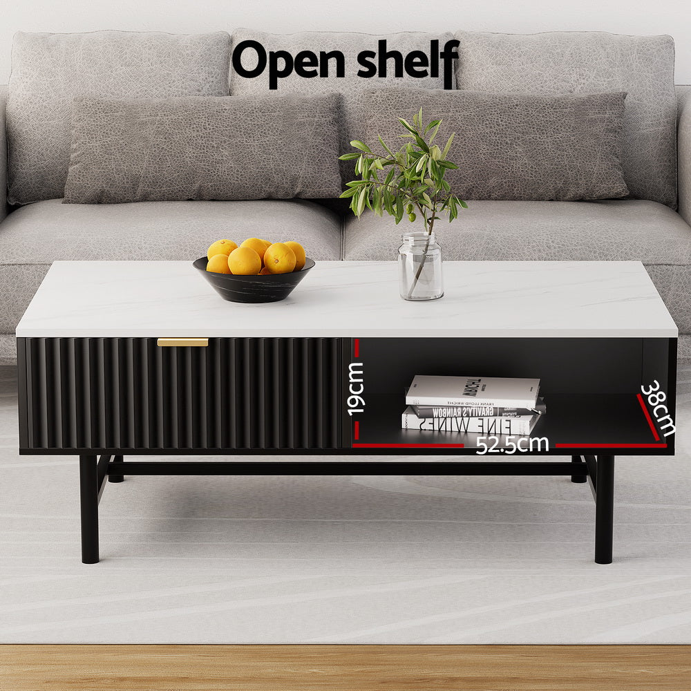 Marble top coffee table with black ribbed drawer, gold handle and open shelf labeled 52.5x38x19cm, grey sofa behind