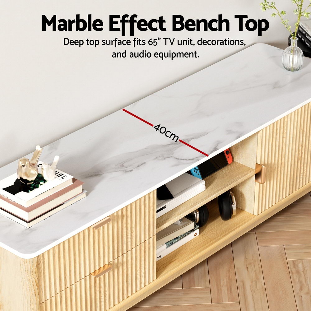 White marble-top TV unit bench top detail 40cm deep fits 65-inch TV with Nintendo Switch and headphones on center shelf