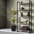 5-shelf metal frame bookcase in black and oak, styled with vases, books, radio and wicker basket in textured wall room scene