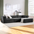 Dark charcoal L-shaped modular sectional sofa with white cushions in modern living room with wooden floor