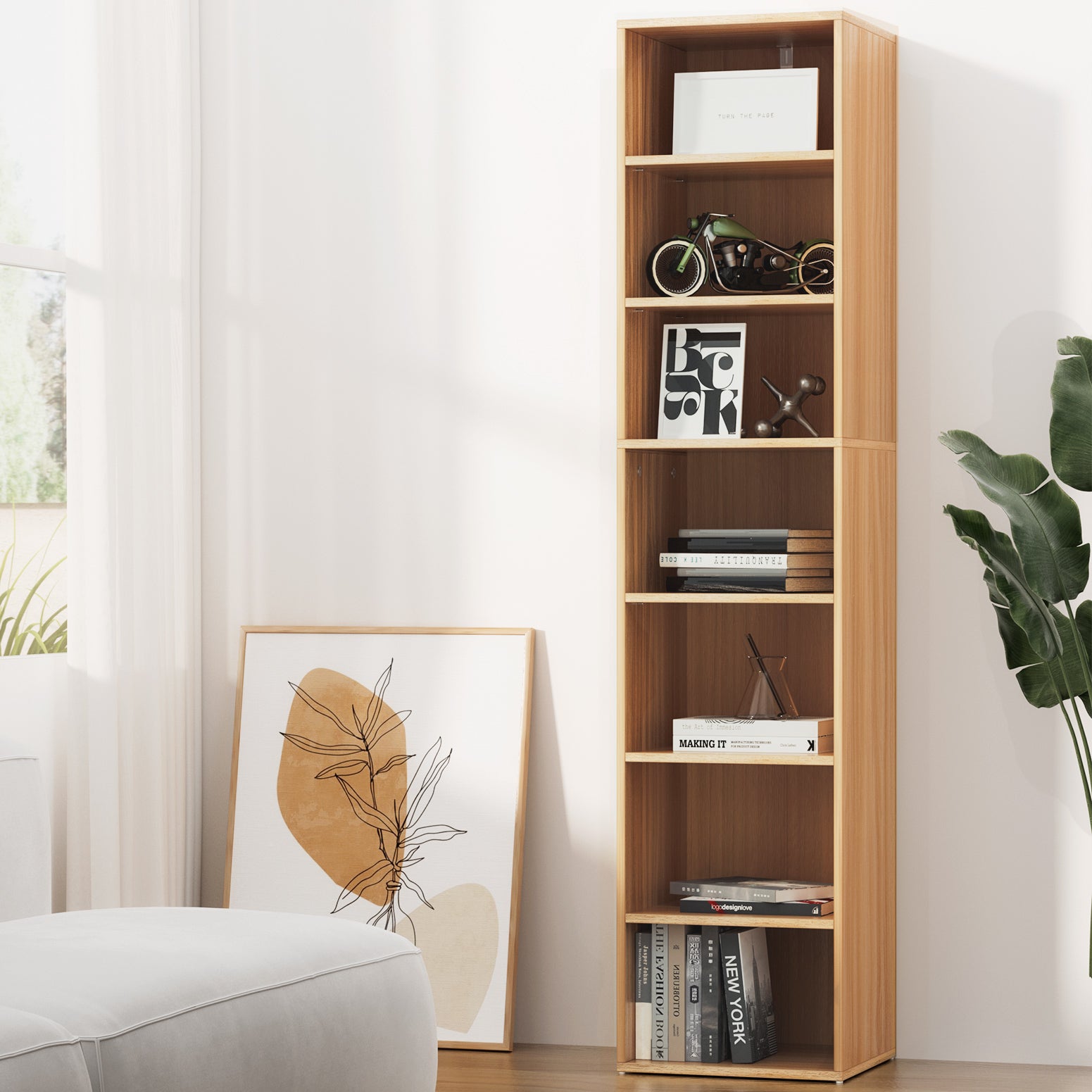 Tall narrow 7-shelf walnut bookcase styled with books and ornaments in bright living room beside armchair and plant