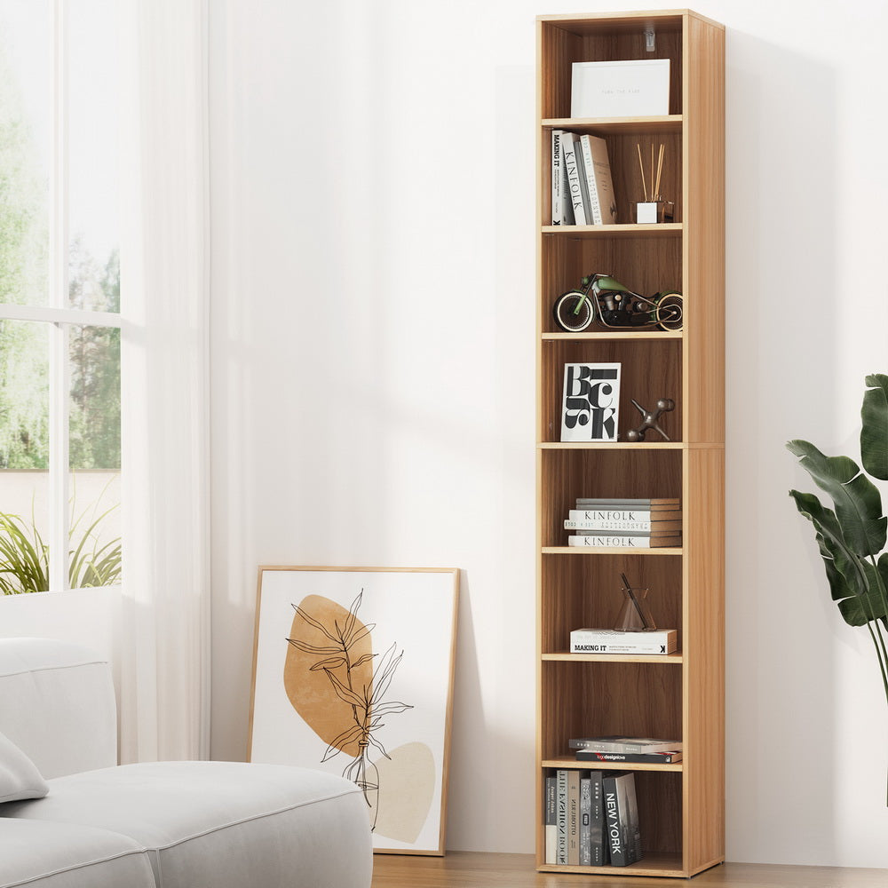 Narrow eight-tier column bookcase in light wood with walnut interior, styled with books and decor in a bright living room