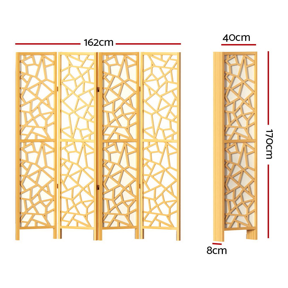 Natural pine 4-panel criss-cross geometric cutout room divider in lifestyle room with plant and round floor cushions