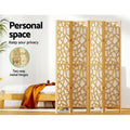 Natural pine 4-panel criss-cross geometric room divider in bedroom lifestyle with personal space and two-way metal hinges