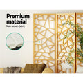 Natural pine 4-panel criss-cross geometric room divider non-woven fabric panel close-up in lifestyle room with palm plant