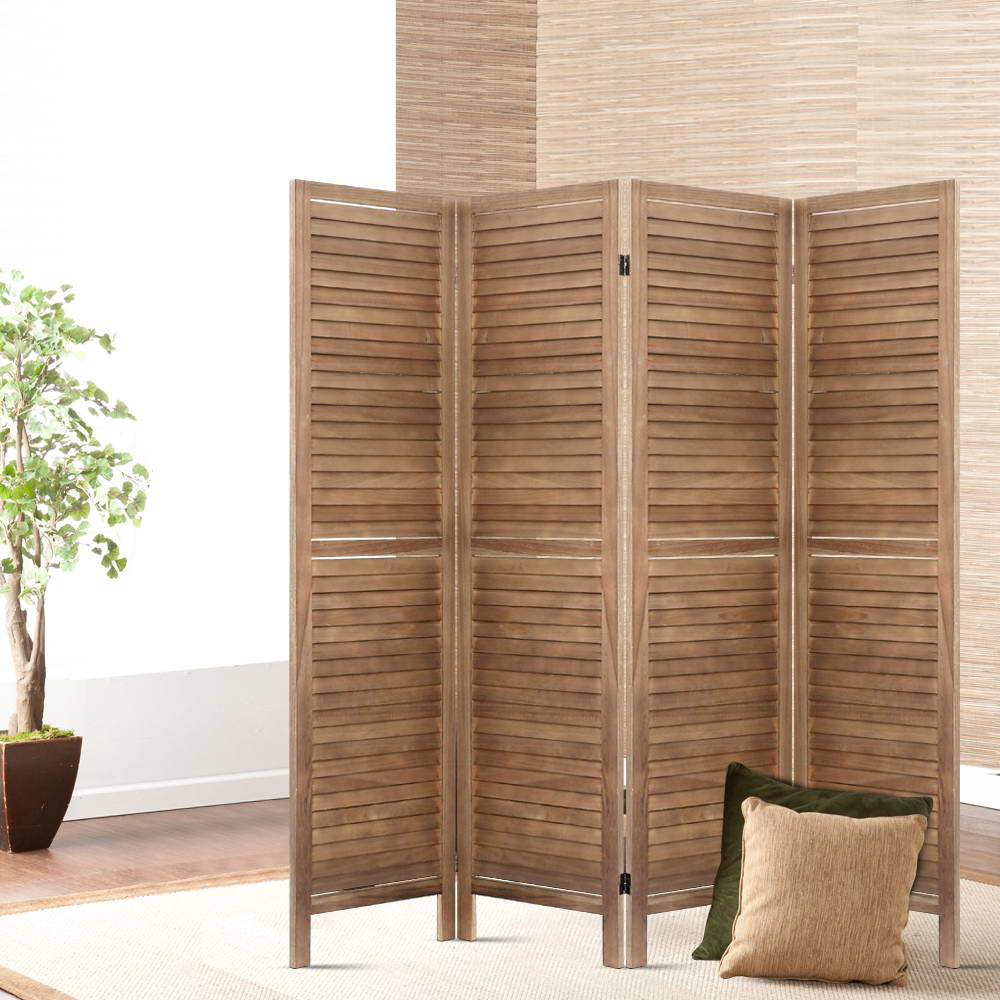 Natural 4-panel louvered wood room divider in lifestyle room with ficus plant floor cushions and woven bamboo wall