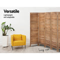 Natural 4-panel louvered wood room divider in living room lifestyle with yellow armchair and ZZ plant against white wall