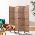 Natural 4-panel woven paper rope room divider in lifestyle room with teal velvet sofa rattan bowl chair and pink cushion