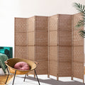 Natural 6-panel woven paper rope room divider in lifestyle room with teal velvet sofa and rattan bowl chair with pink cushion