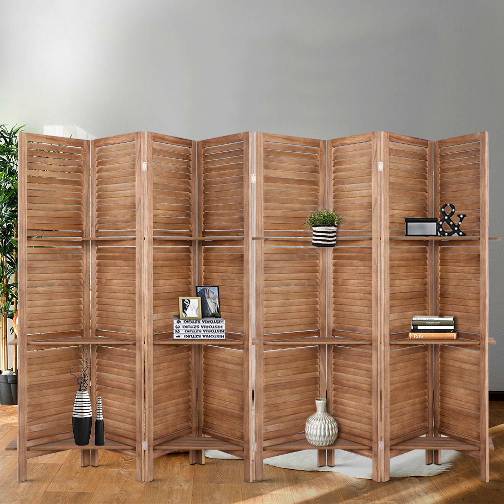 Natural 8-panel louvered paulownia wood room divider with shelves in grey wall lifestyle with vases books plants and frames