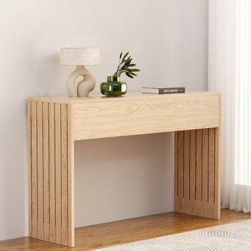 Natural oak console table with vertical wood slat side panels, lamp and glass vase with plant on top, warm room setting