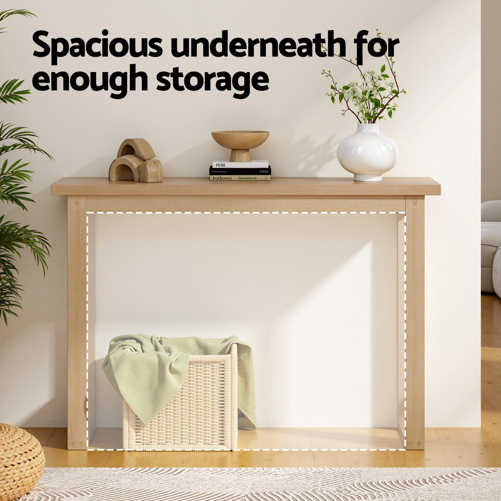 Natural oak console table in living room with wicker basket underneath, text "Spacious underneath for enough storage"