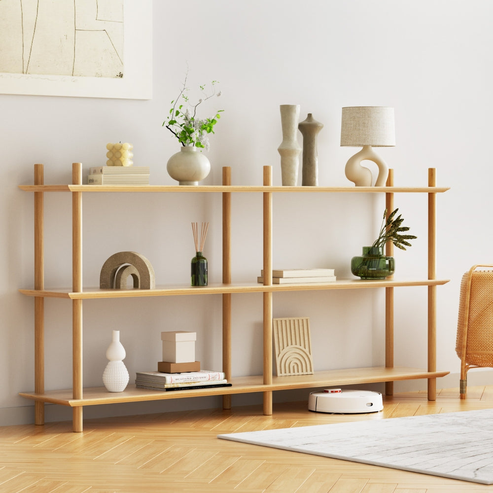 3-tier natural wood open shelf styled with vases, books and lamp in living room with robot vacuum visible under bottom shelf