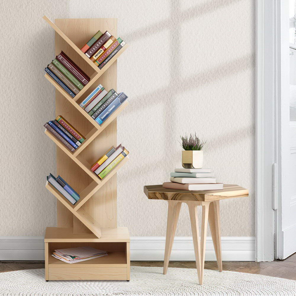 Natural wood 7-tier tree-shaped bookshelf filled with books, neutral room with wooden side table and potted heather