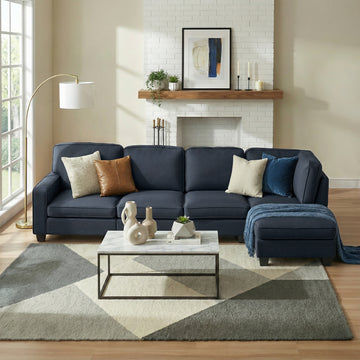 Dark navy 5-seat fabric sectional sofa with chaise in living room with white brick fireplace and rug