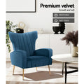 Navy blue velvet wingback armchair with gold legs in living room, 