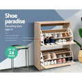 Oak two-door shoe cabinet both flip-out trays open with multiple shoe pairs shoe paradise up to 24 pairs badge visible