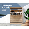 Oak two-door shoe cabinet top flip-out open with black and white shoes stored lower door closed clutter-free entrance text