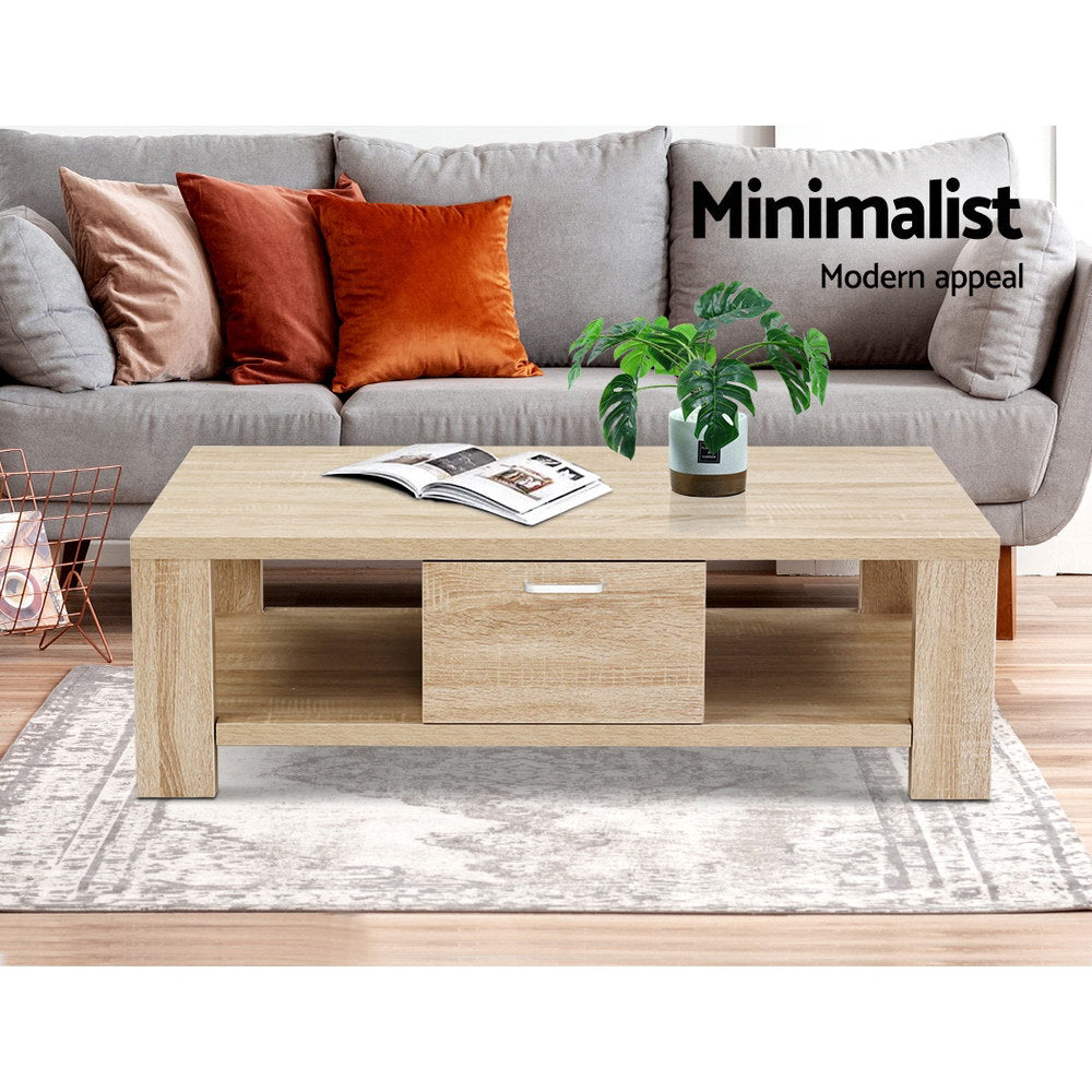 Light oak coffee table with drawer in front of grey sofa with terracotta cushions, text Minimalist Modern appeal