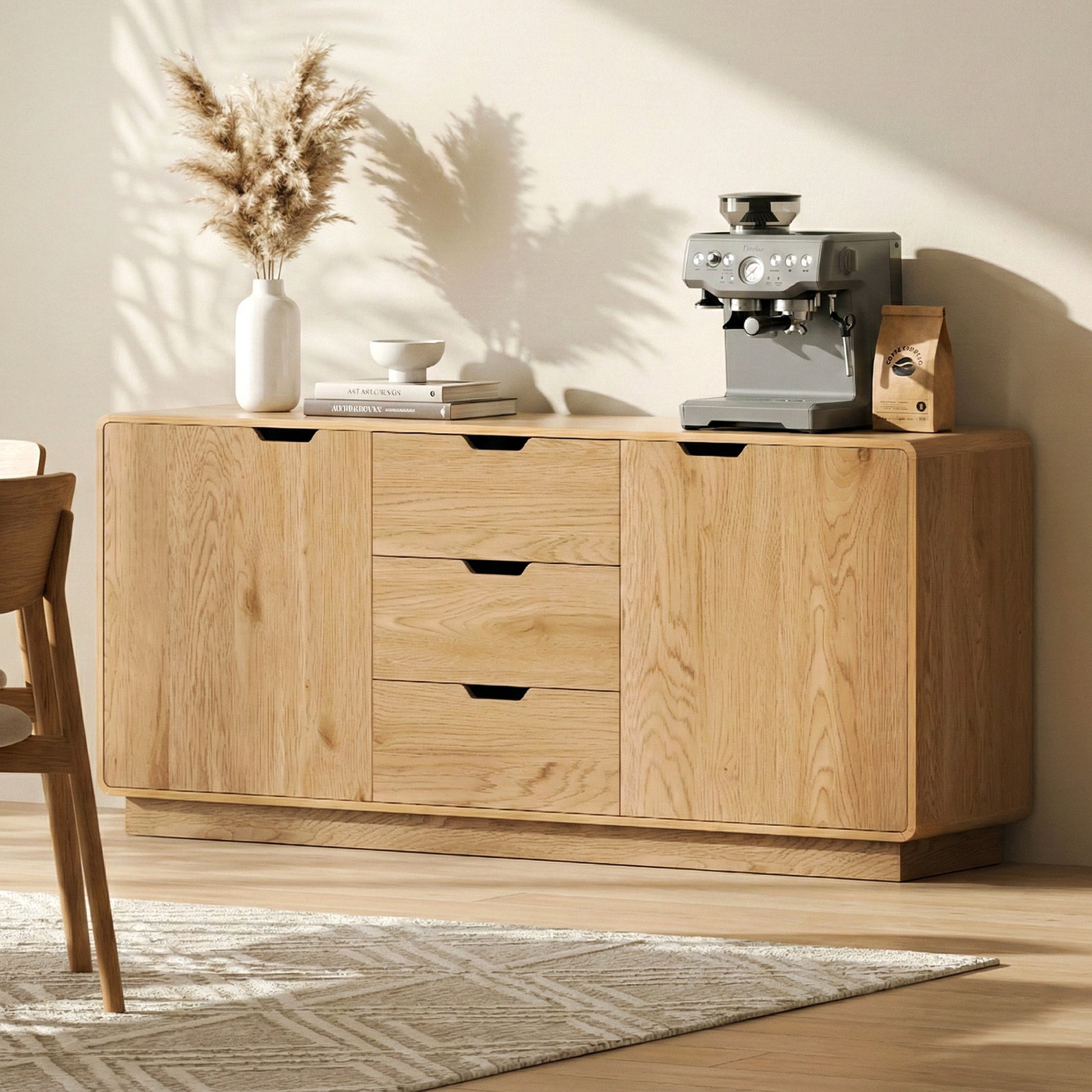 Oak grain sideboard in warm room setting with coffee machine, vase and books on top, three central drawers visible