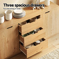 Three open drawers of oak grain sideboard showing dishes and bowls inside, text reads Three spacious drawers