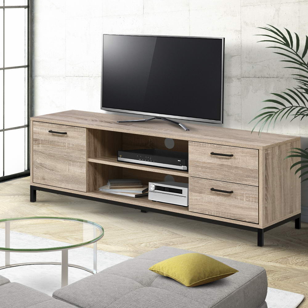 Oak industrial TV stand with one door and two drawers on black metal legs in concrete-walled room