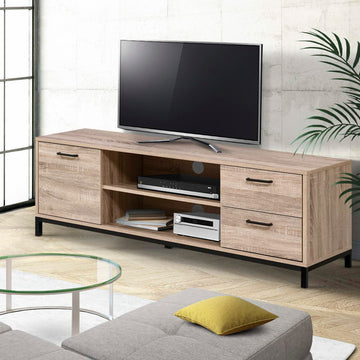 Oak industrial TV stand with one door and two drawers on black metal legs in concrete-walled room